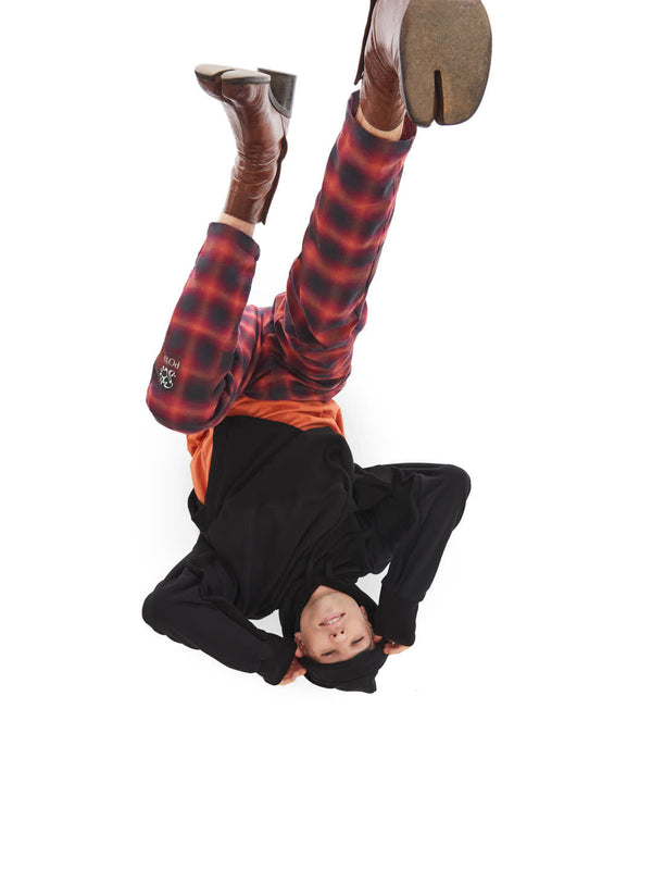 upside down model featuring tailored pants and upcycled poncho