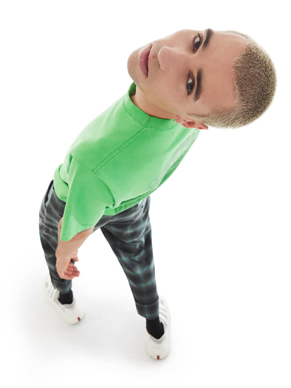 model in a relaxed pose featuring upcycled t-shirt and tailored pants