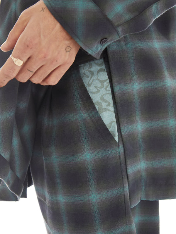 detail of a pocket with monogram on tailored pants made from upcycled cotton