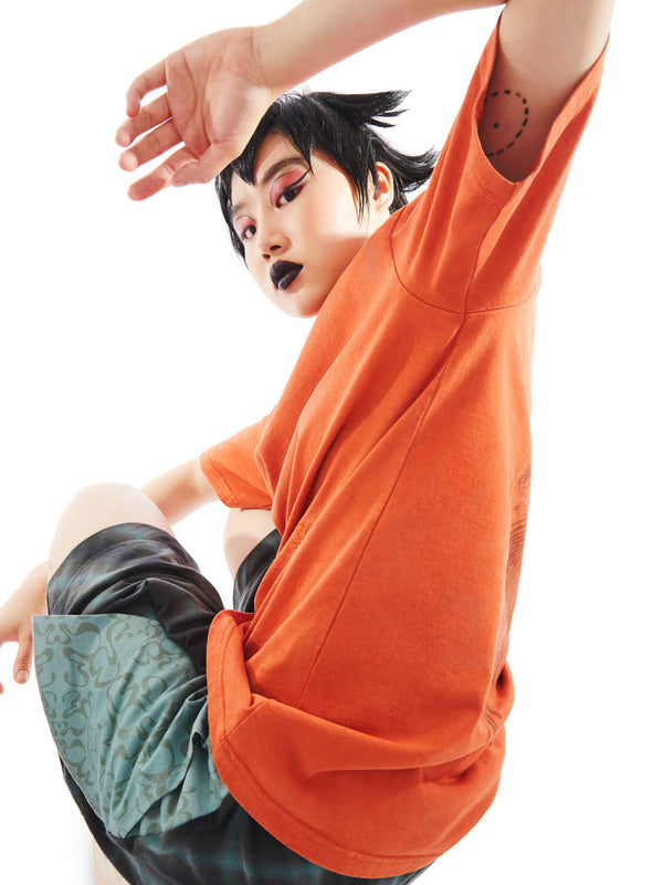 model on a relaxed pose featuring the back of orange t-shirt