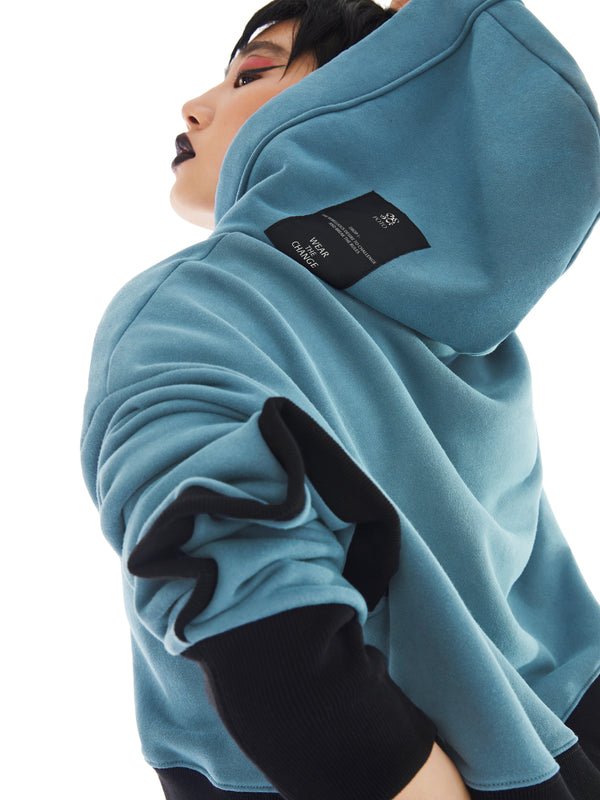 hood of teal and black poncho with brand tag on the side